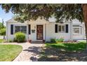 Charming single-story home with a brick walkway, green lawn, and mature landscaping at 4197 S Grant St, Englewood, CO 80113