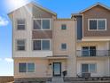 Modern townhome showcasing a brick facade and cozy balcony, illuminated by bright daylight at 14451 Pansy Loop, Morrison, CO 80465