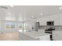 Bright, modern kitchen features a large island, stainless appliances, and sleek white cabinetry at 14451 Pansy Loop, Morrison, CO 80465