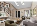 Bright living room featuring skylights, vaulted ceilings, and modern furnishings at 2043 Fendlebrush St, Highlands Ranch, CO 80129