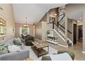 Open-concept living area with stairs, neutral paint, modern decor, and wood floors at 2043 Fendlebrush St, Highlands Ranch, CO 80129