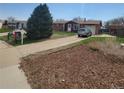 Cozy home with a long driveway leading to an attached garage, with mature landscaping at 9008 Dover St, Broomfield, CO 80021