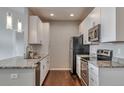 Kitchen with white cabinets, stainless steel appliances, and granite countertops at 14251 E 1St Dr # 308, Aurora, CO 80011