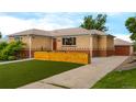 Exterior shot of the home and detached garage featuring a well maintained lawn at 4891 Depew St, Denver, CO 80212