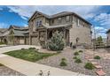 Charming two-story home with a stone and siding exterior, a covered porch, and landscaped front yard at 8133 Arapahoe Peak St, Littleton, CO 80125