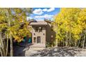 Charming two-story home featuring well-maintained landscaping and a welcoming entrance surrounded by colorful trees at 537 Moonstone Rd, Breckenridge, CO 80424