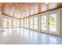 Bright sun room featuring a wood ceiling, tile flooring, and multiple glass doors that lead to the backyard at 6935 W 16Th Ave, Lakewood, CO 80214