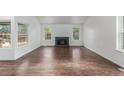 Inviting living room with hardwood floors, a fireplace, and ample natural light through large windows at 2026 S Pitkin St, Aurora, CO 80013