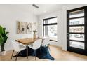 Modern dining room features a wooden table, white chairs, a cowhide rug, and a large window at 2391 King St, Denver, CO 80211
