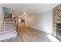 Bright living room with hardwood floors, fireplace, and staircase access at 6776 S Holland Way, Littleton, CO 80128
