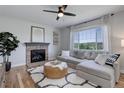 Cozy living room featuring a stone fireplace, plush seating, and a large window with scenic views at 5528 Echo Hollow St, Castle Rock, CO 80104