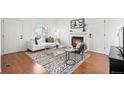 Living room with fireplace, white sofa with decorative pillows, and hardwood flooring at 1248 W 135Th Ave, Denver, CO 80234