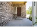 Inviting front porch featuring a brick facade and a covered entrance to the home at 24664 E Louisiana Cir, Aurora, CO 80018