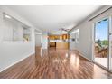 Open-concept living and kitchen area with hardwood floors and a sliding glass door at 9638 Marion Way, Thornton, CO 80229
