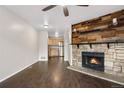 Open-concept living room with a stone fireplace and updated flooring at 185 S Sable Blvd # T18, Aurora, CO 80012