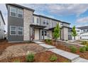 Beautiful townhome featuring a stone facade, well-maintained landscaping, and a red front door at 20520 E 58Th Ave, Aurora, CO 80019