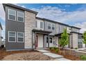 Inviting entryway to this modern townhome with stylish stonework and a vibrant red door at 20520 E 58Th Ave, Aurora, CO 80019