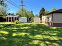 Spacious backyard with green lawn, storage sheds, and potential for outdoor activities at 2124 S Yates St, Denver, CO 80219