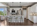 Bright, modern kitchen with white cabinets, stainless steel appliances, granite countertops, and pendant lighting at 2794 Lima St, Denver, CO 80238