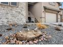 Beautiful landscaped front yard featuring a stone water feature and unique foliage at 878 Tree Bark Ter, Colorado Springs, CO 80132
