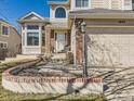 Inviting home entrance with brick accents, manicured landscaping, and a well-lit walkway at 5843 S Danube St, Aurora, CO 80015