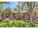 Charming exterior view of this brick home with a well maintained lawn and mature trees at 764 S Sherman St, Denver, CO 80209
