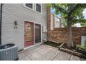 Private patio with brick wall, small lawn area, and access from a red door at 1150 Inca St # 59, Denver, CO 80204