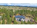 A captivating aerial view of a home nestled amidst lush greenery and rolling hills at 24701 Us Hwy 40, Golden, CO 80401