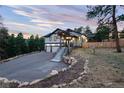 Stunning home exterior showcasing stone accents, a long driveway, and beautiful landscaping at 24701 Us Hwy 40, Golden, CO 80401