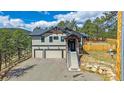 Inviting two-story home featuring a stone porch, a three-car garage and mature landscaping at 24701 Us Hwy 40, Golden, CO 80401