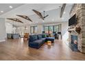 Bright living room featuring a stone fireplace, exposed beams and hardwood floors at 24701 Us Hwy 40, Golden, CO 80401