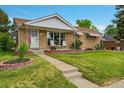 Charming single-story home with a well-manicured lawn and cozy front porch setting at 2121 W 73Rd Pl, Denver, CO 80221