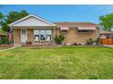 Well-maintained single-Gathering home boasts a lovely lawn and inviting front porch at 2121 W 73Rd Pl, Denver, CO 80221