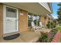 Inviting front porch features seating and charming brick accents, perfect for relaxing outdoors at 2121 W 73Rd Pl, Denver, CO 80221