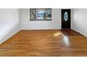 Empty living room with hardwood flooring, a large window, and a modern door at 13477 E Center Ave, Aurora, CO 80012