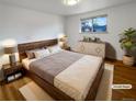Staged bedroom with hardwood floors, large window, and elegant furnishings at 13477 E Center Ave, Aurora, CO 80012