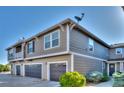 View of condo complex with garage parking and well maintained exterior siding and roofing at 17205 Waterhouse Cir # C, Parker, CO 80134