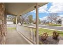 Inviting covered front porch with white railings and stone accents, offering a pleasant view of the neighborhood at 13906 Jackson St, Thornton, CO 80602
