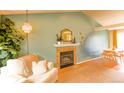 Comfortable living room featuring a decorative fireplace, hardwood floors, and cozy seating area at 12498 W Prentice Dr, Littleton, CO 80127