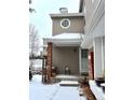 Side view of townhome showcasing entryway, brickwork, and winter landscaping at 9866 Carmel Ct, Lone Tree, CO 80124