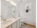 Bright bathroom featuring a double sink vanity, a window, and a combined tub and shower at 6615 N Nepal St, Aurora, CO 80019