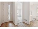 Bright entryway with wood-look floors, leading to a living area and a half bathroom at 6615 N Nepal St, Aurora, CO 80019
