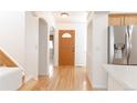 Hardwood floor hallway with an interior door and kitchen access at 19877 E 40Th Ave, Denver, CO 80249