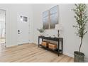 Bright foyer features light wood floors, neutral walls, console table with decor, and a view of the front door at 11103 Cloud Shadow St, Littleton, CO 80125