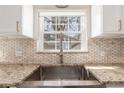 Close-up of kitchen sink with modern faucet, granite countertops, and window view at 3577 S Hillcrest Dr, Denver, CO 80237
