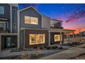 Charming townhome exterior with a brick facade, open rooftop deck, and inviting curb appeal at dusk at 888 S Valentia St # 106, Denver, CO 80247