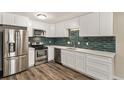 Updated kitchen with stainless steel appliances, sleek countertops, and stylish backsplash at 3460 S Poplar St # 404, Denver, CO 80224