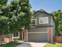 Charming two-story home featuring brick accents, a two-car garage, and a well-manicured lawn at 2548 Foothills Canyon Ct, Highlands Ranch, CO 80129