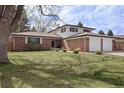 Charming two-story brick home with a well-maintained lawn and mature trees at 1581 S Kendall St, Lakewood, CO 80232