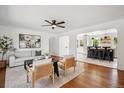 Bright living room featuring hardwood floors, a ceiling fan, and access to the kitchen at 1860 W Iris Cir, Littleton, CO 80120